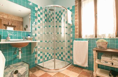Baño de azulejo verde y blanco con ducha acristalada