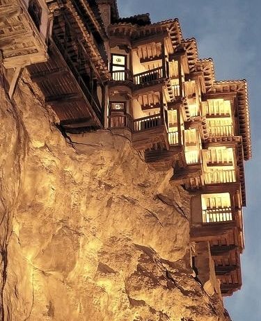 Las Casas Colgadas vistas desde el pie de la roca, iluminadas al anochecer