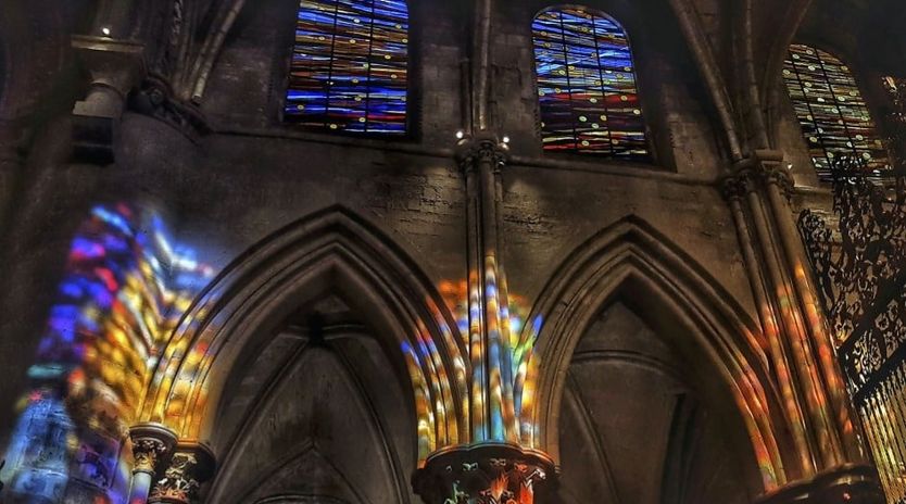 Vidrieras de colores de la catedral de Cuenca reflejadas en sus arcos góticos
