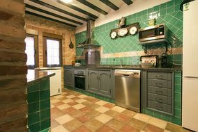 Cocina equipada de azulejo verde con horno, lavavajillas y campana