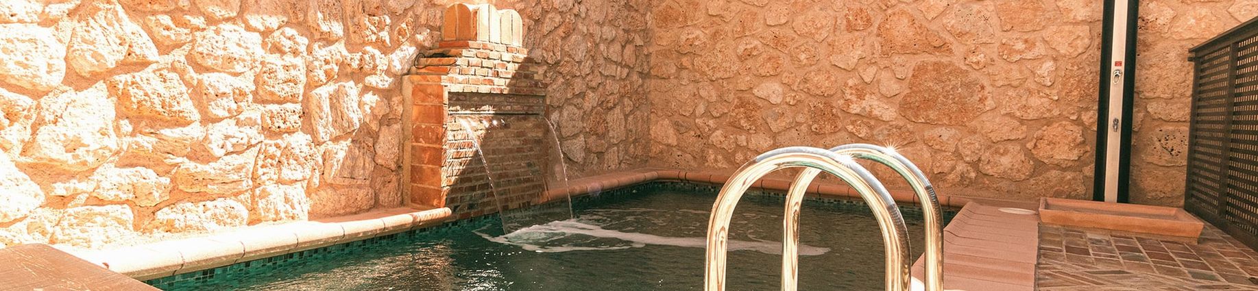 Piscina de la casa entre muros de piedra